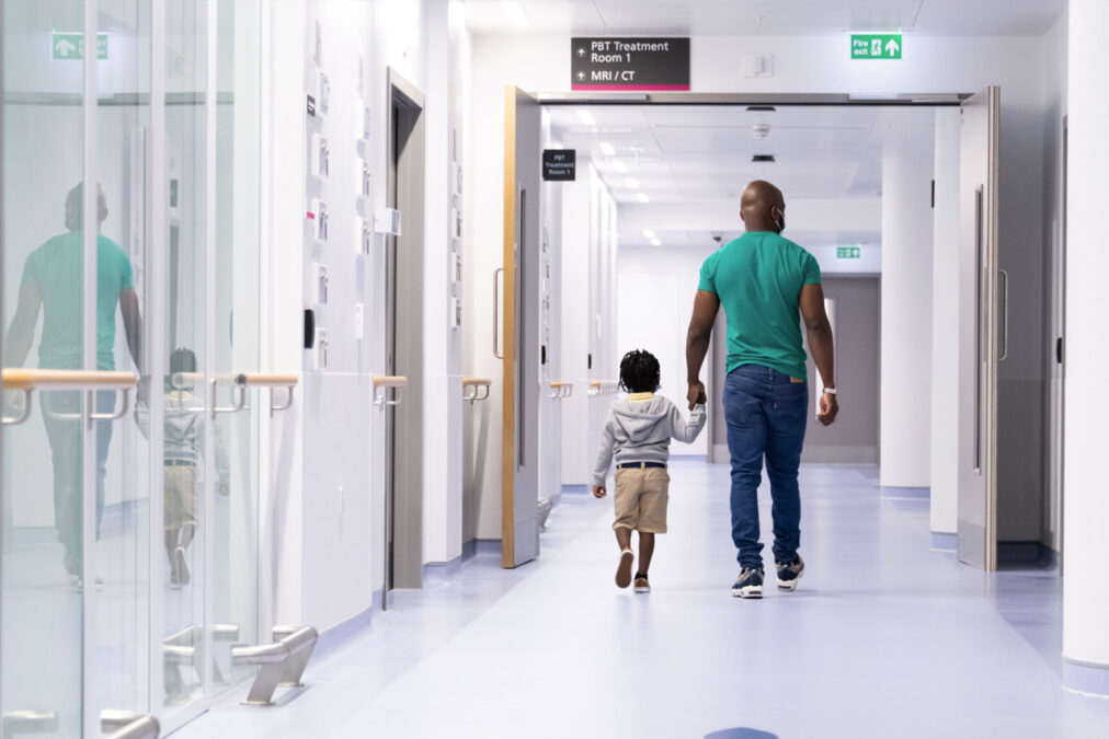 parent and child walking to proton therapy treatment