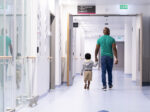 parent and child walking to proton therapy treatment