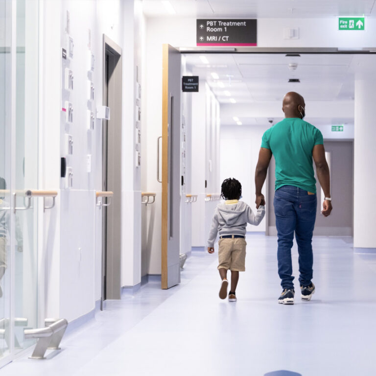 parent and child walking to proton therapy treatment